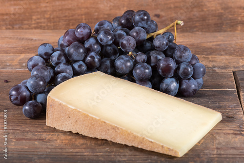 French comté cheese with black grapes