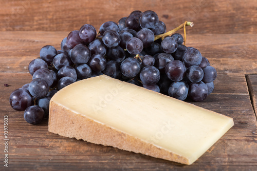 French comté cheese with black grapes photo