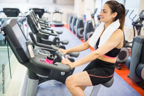 Smiling woman using the exercise bike