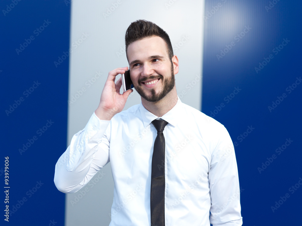 Businessman using cellphone, handsome businessman on creative ba Businessman using cellphone, handsome businessman on creative ba