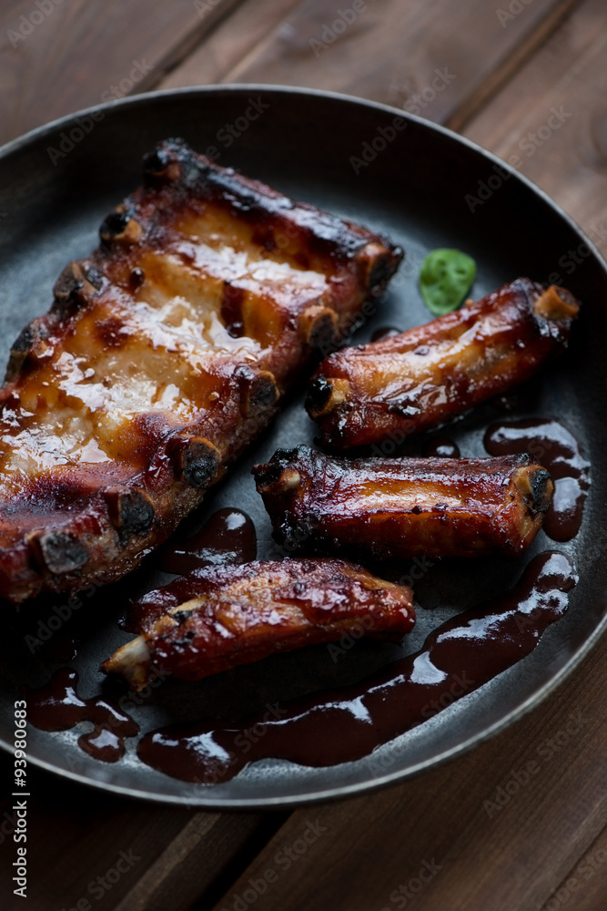 Close-up of baked pork ribs with sauce, studio shot