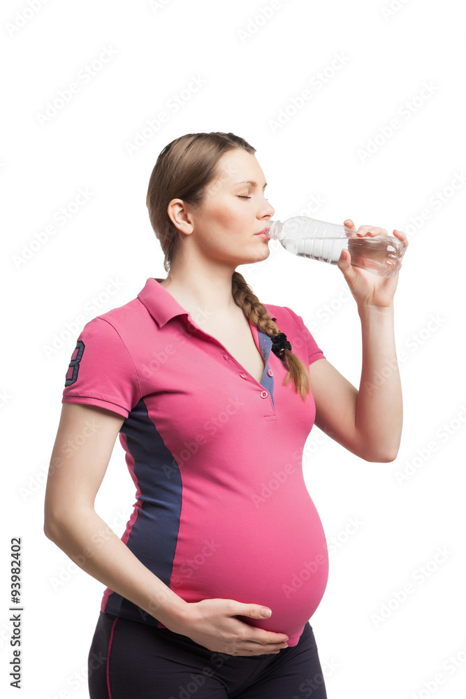 Young pregnant woman drinking water after exercises Young pregnant woman drinking water after exercises