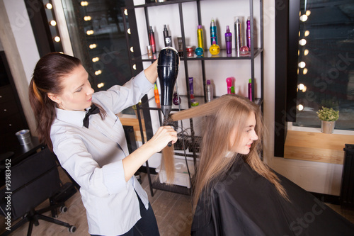 Hairstylist Drying Hair Blonde in Salon 