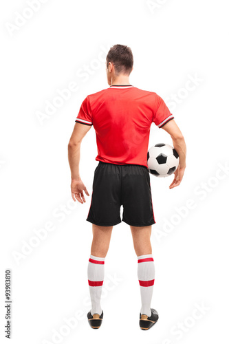 Fototapeta Naklejka Na Ścianę i Meble -  Football player in red jersey holding a ball