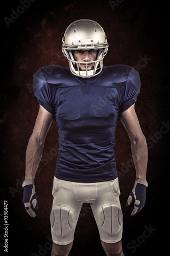 Composite image of serious american football player standing