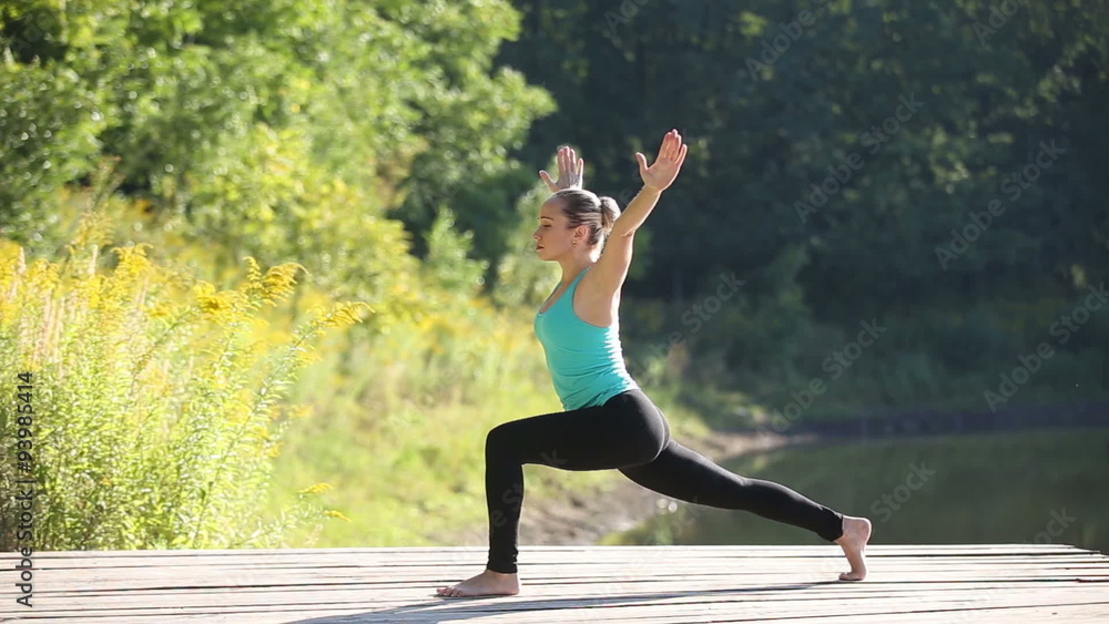 Young beautiful woman doing warrior 1 and plank yoga postures in park Young beautiful woman doing warrior 1 and plank yoga postures in park