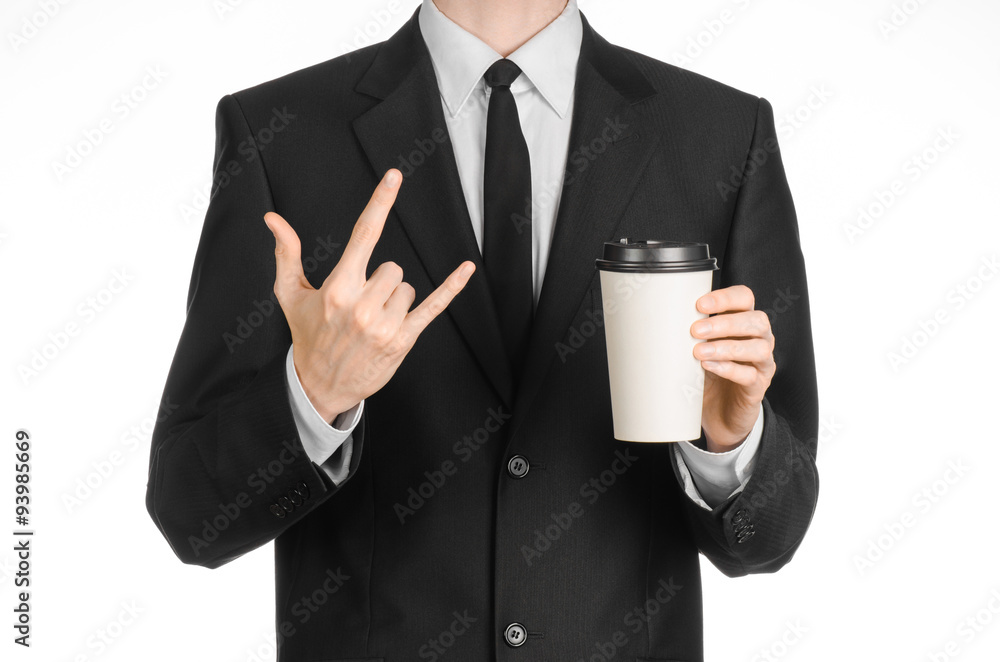 Business lunches coffee theme: businessman in a black suit holding a white blank paper cup of coffee with a brown plastic cap isolated on a white background in the studio, advertising coffee Business lunches coffee theme: businessman in a black suit holding a white blank paper cup of coffee with a brown plastic cap isolated on a white background in the studio, advertising coffee