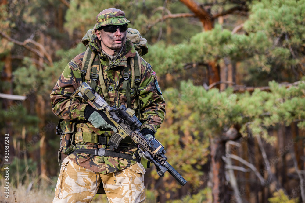 Infantryman with rifle in forest/Soldier in uniform with rifle in his hands on forest background
