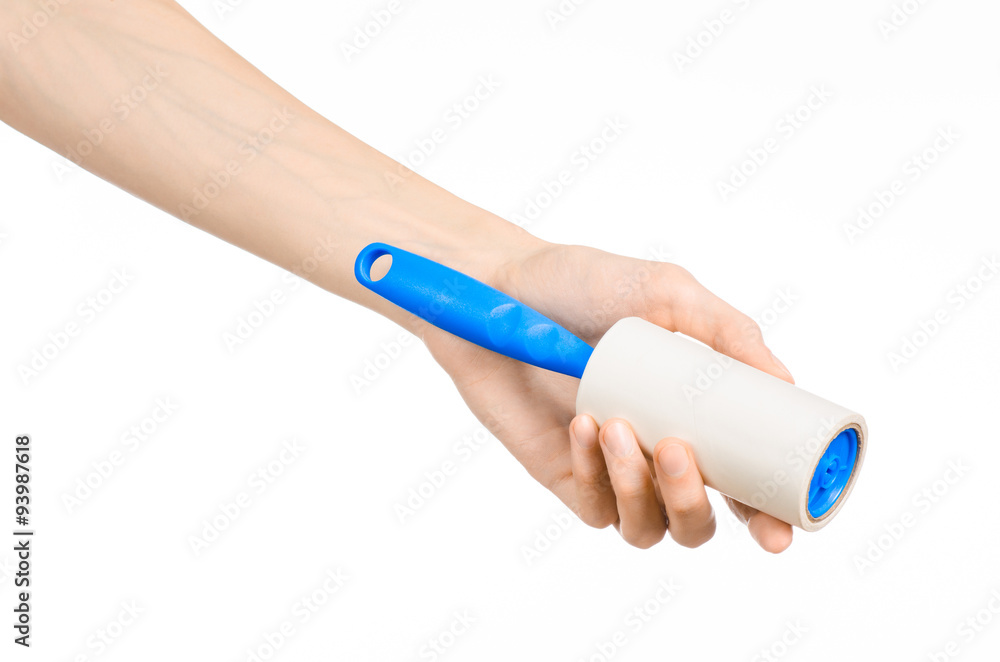 Clean clothes and cleaning the house topic: human hand holding a blue sticky brush for cleaning clothes and furniture from dust isolated on white background in studio. Clean clothes and cleaning the house topic: human hand holding a blue sticky brush for cleaning clothes and furniture from dust isolated on white background in studio.