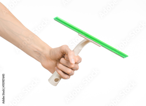 Household cleaning and washing windows theme: man's hand holding a green scraper windows isolated on a white background in the studio.