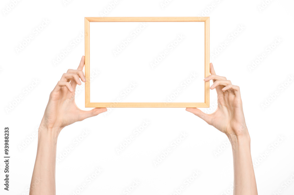 House decoration and Photo Frame topic: human hand holding a wooden picture frame isolated on a white background in studio House decoration and Photo Frame topic: human hand holding a wooden picture frame isolated on a white background in studio