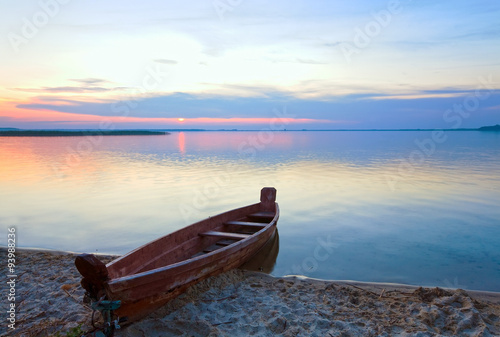 Sunset with boat near the summer lake shore