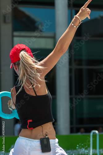 Blonde Female Instructor with Red Hat Teaching Aqua Aerobics at