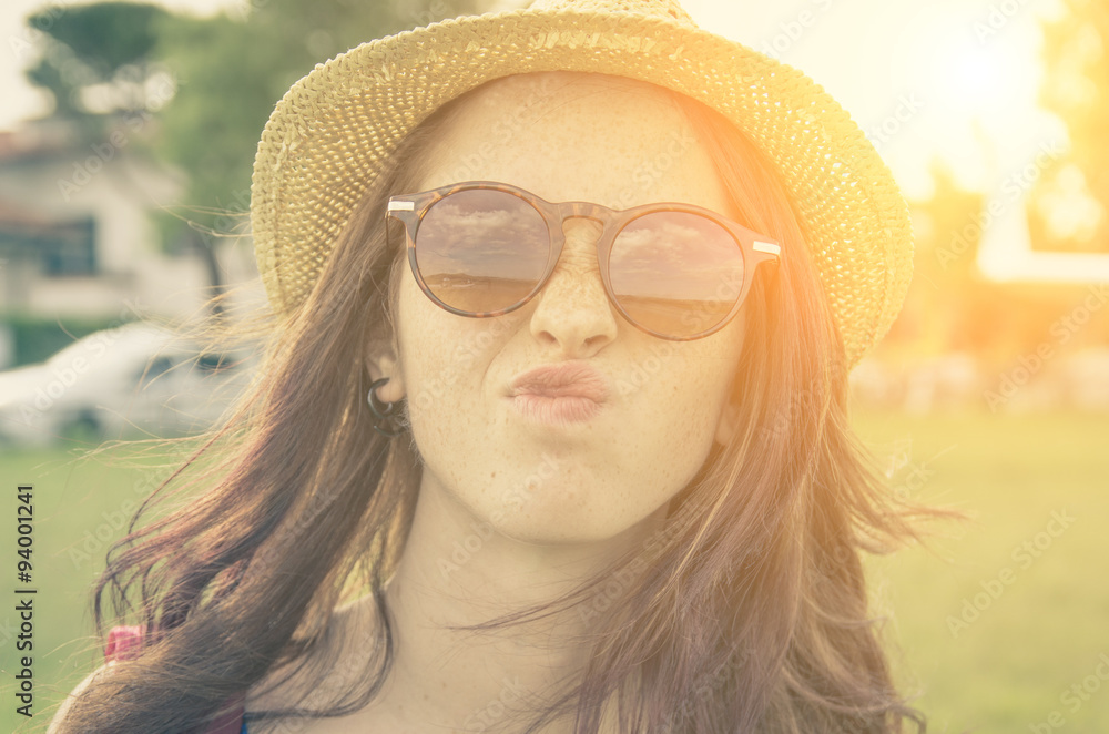 Close-up of a girl with sunglasses and a straw hat in a sunny day - caucasian people - people concept Close-up of a girl with sunglasses and a straw hat in a sunny day - caucasian people - people concept