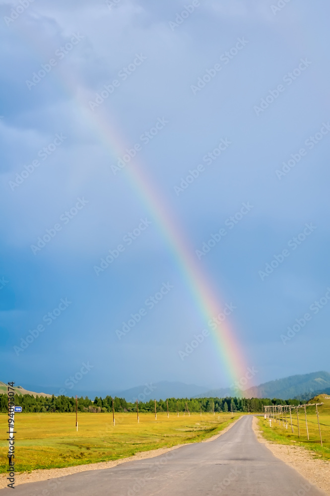 Rainbow above road in Mountain Altai. Russia