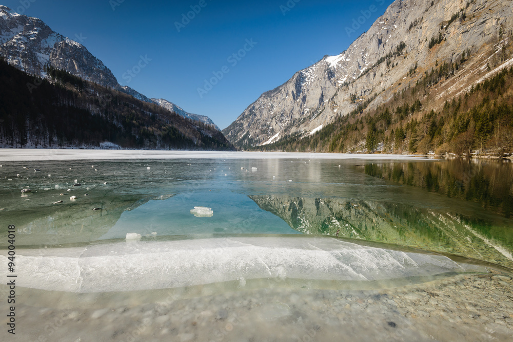 Winter landscape with frozen lake and mountains in background.Leopoldsteinersee,Styria,Austria.