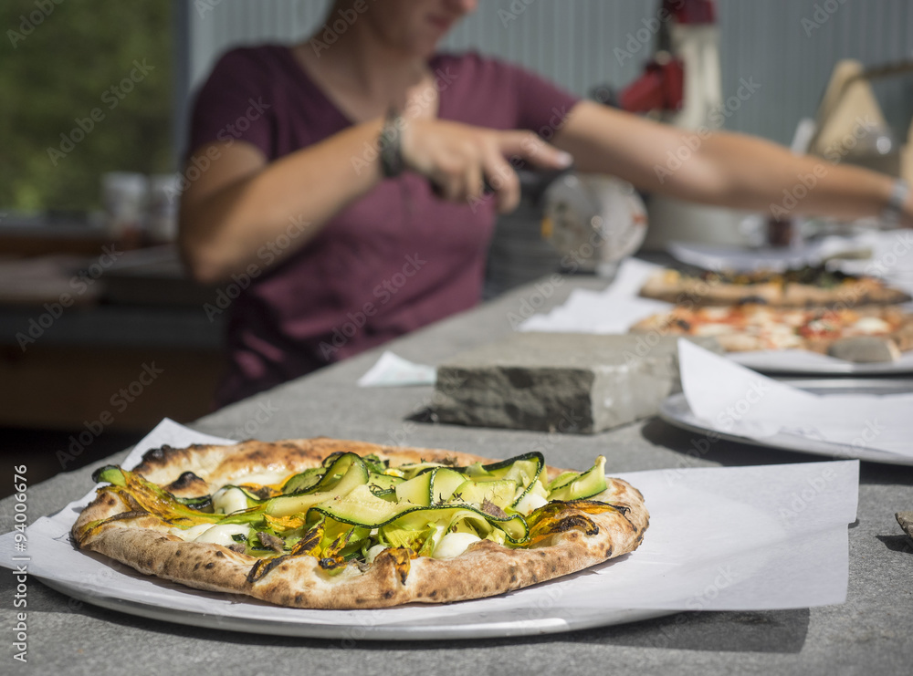 Fresh Zucchini and Ricotta Pizza Just Out of the Oven: Fresh Zucchini and Ricotta Pizza just out of the oven on a counter with other pizzas and pizza cutter in background