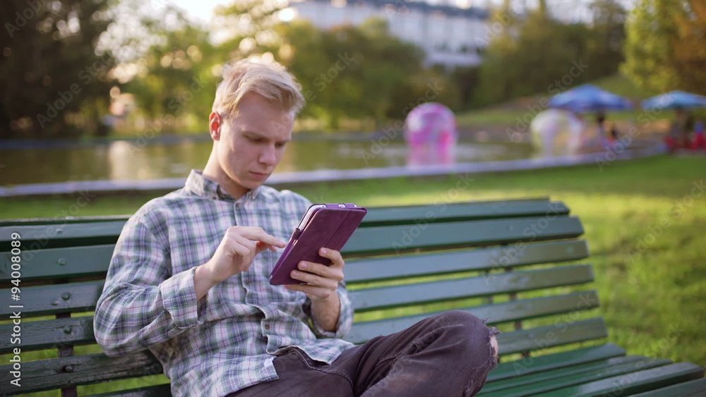 Happy boy sitting in the park and browsing internet on tablet
Happy boy sitting in the park and browsing internet on tablet