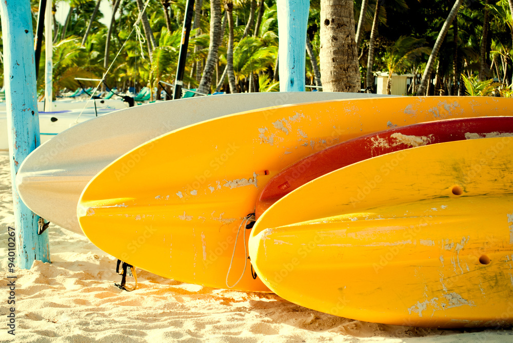 Colorful paddle boards on the beach in Punta Cana, Dominican Republic. Summer vacation and water sports concept Colorful paddle boards on the beach in Punta Cana, Dominican Republic. Summer vacation and water sports concept