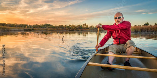 paddling canoe at sunset photo