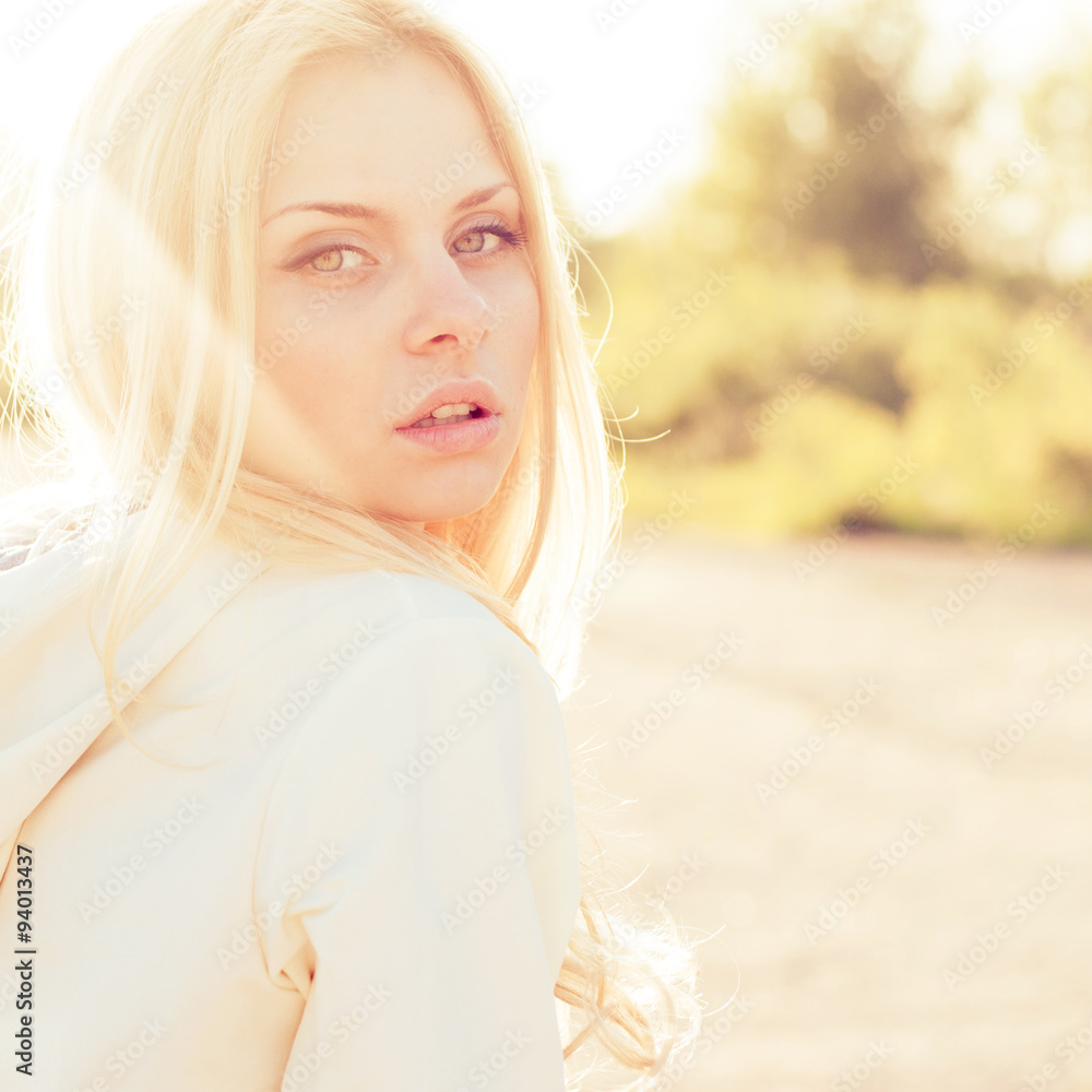 Blonde girl close-up portrait in sun-rays