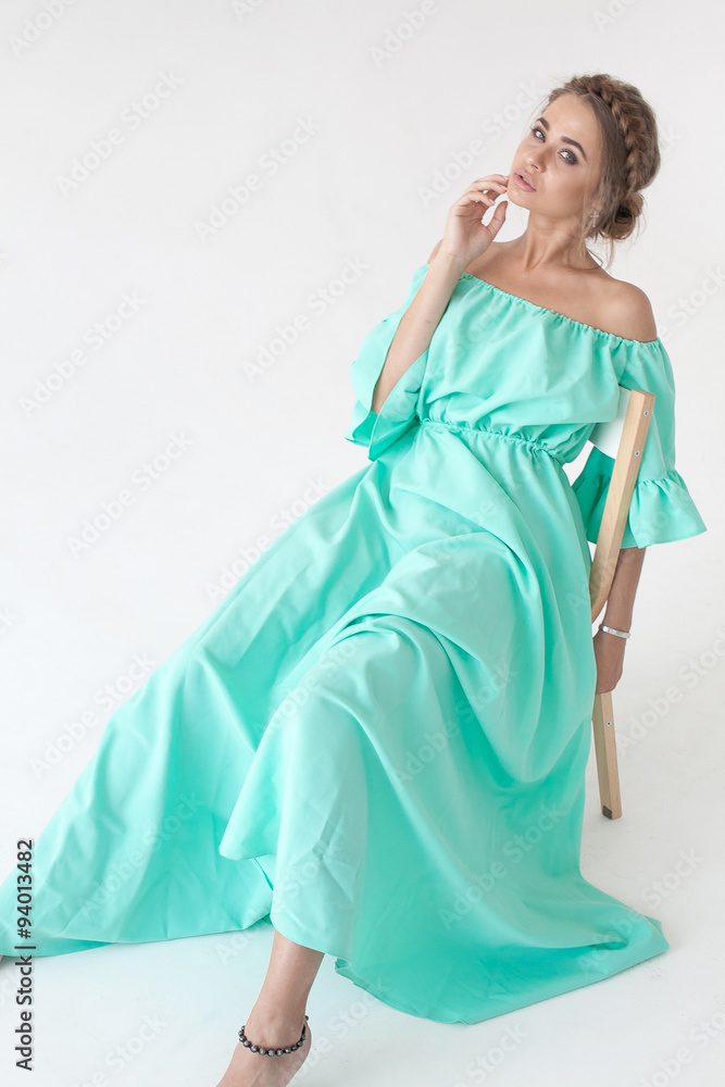 Portrait of beautiful woman with makeup and hairstyle in a turquoise dress Portrait of beautiful woman with makeup and hairstyle in a turquoise dress