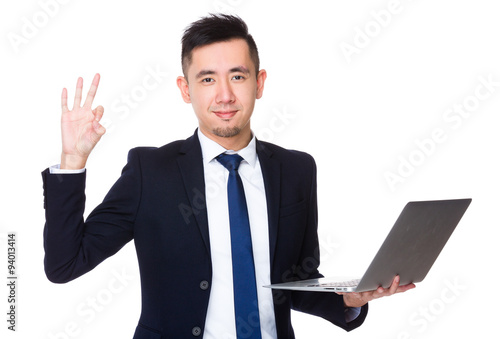 Young businessman hold with laptop computer and ok sign gesture