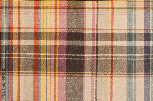 Scottish tartan pattern. Orange and green with yellow plaid print as background. Colored lines and square pattern. Scottish checked fabric.