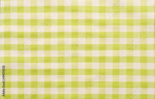 Close up on checkered tablecloth fabric. Green with white tartan square pattern as background.