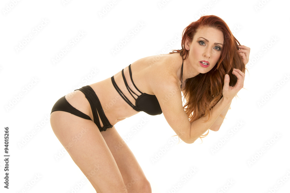 woman with red hair black bikini bend over looking Stock Photo | Adobe Stock