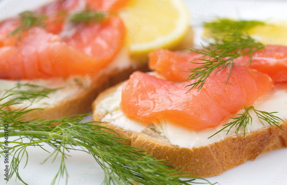 Sandwich with smoked salmon, cream cheese and lemon on plate Sandwich with smoked salmon, cream cheese and lemon on plate