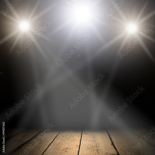 concert spot lighting over dark background and wood floor