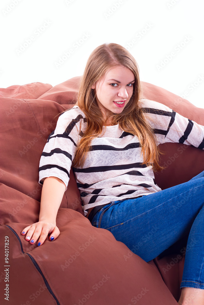 girl sitting on a braun beanbag chair.