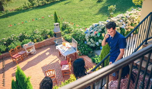 Photos Young man calling by phone over barbecue background
