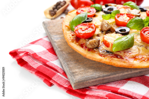 Tasty pizza with vegetables and basil close up