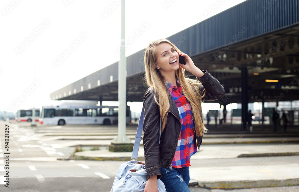 Smiling young woman traveling with bag and mobile phone Smiling young woman traveling with bag and mobile phone