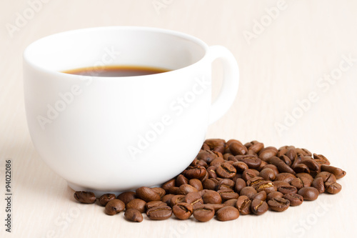 Coffee Cup and coffee beans on wooden table