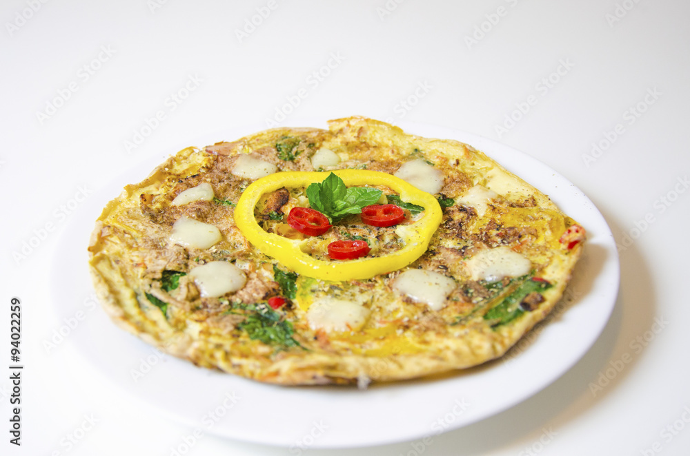 Spinach chili and pepper omelette.A spinach, chili, mint and pepper omelette in a dish in white background. A healthy diet meal omelet.