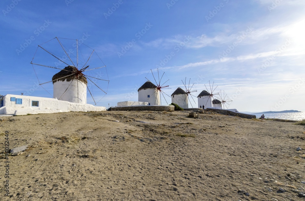 Five windmills in Chora,Mykonos,Greece.Traditional greek whitewashed architecture,a popular landmark,tourist destination on the island of winds,deep blue sky,Aegean sea. Wind mills are now decorative. Five windmills in Chora,Mykonos,Greece.Traditional greek whitewashed architecture,a popular landmark,tourist destination on the island of winds,deep blue sky,Aegean sea. Wind mills are now decorative.