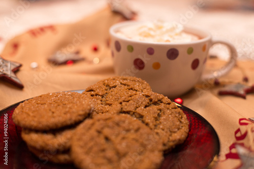 Homemade molasses cookies on Christmas serving plate with mug of hot chocolate