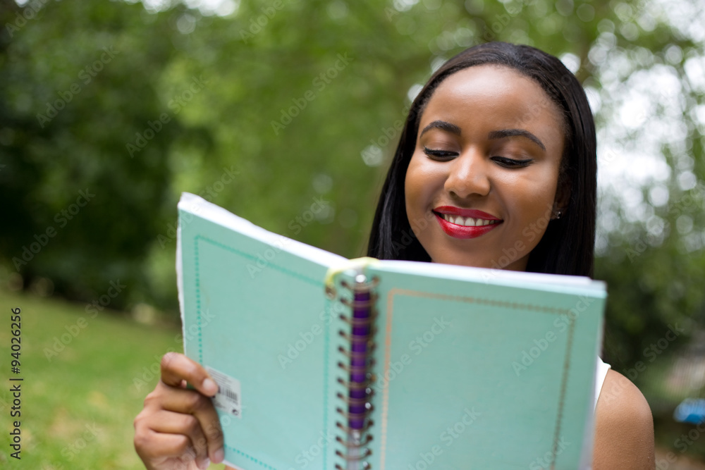 girl in the park reading a notebook girl in the park reading a notebook
