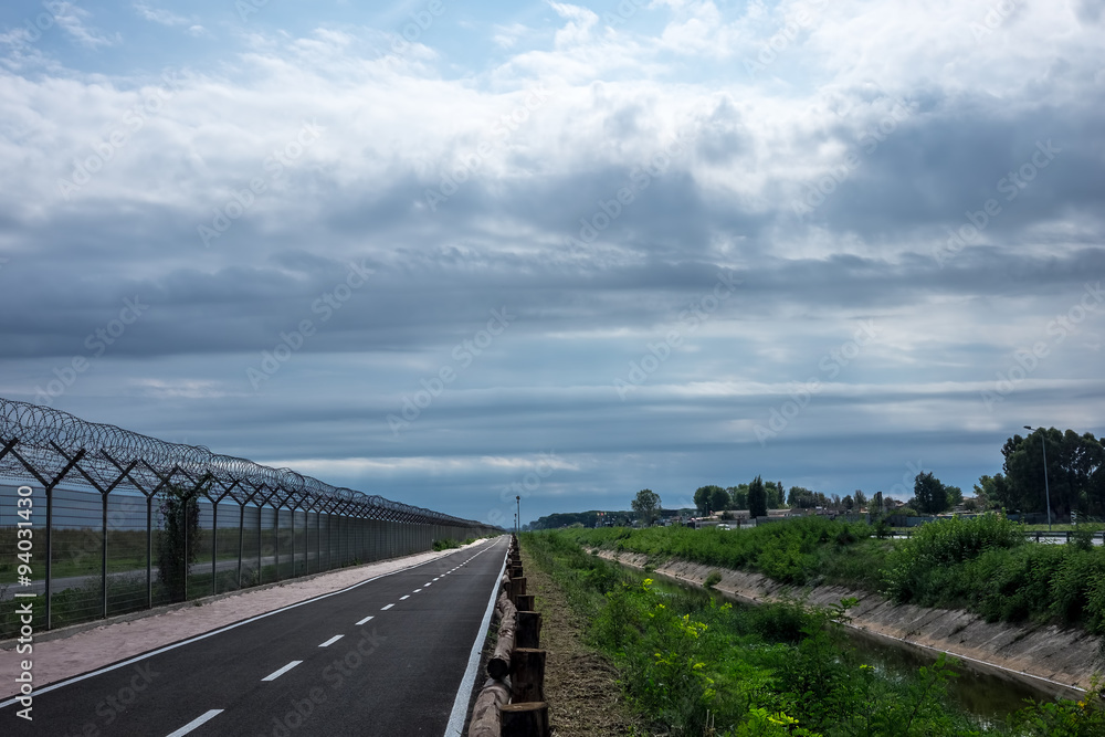 Empty Road in a Cloudy Afternoon Along a River
