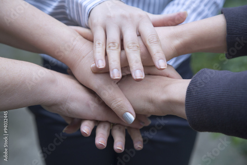 Stack of hands gathering in unity.