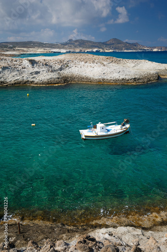 Small fishing boat in Mytakas bay on the northern coast of Milos island. © milangonda