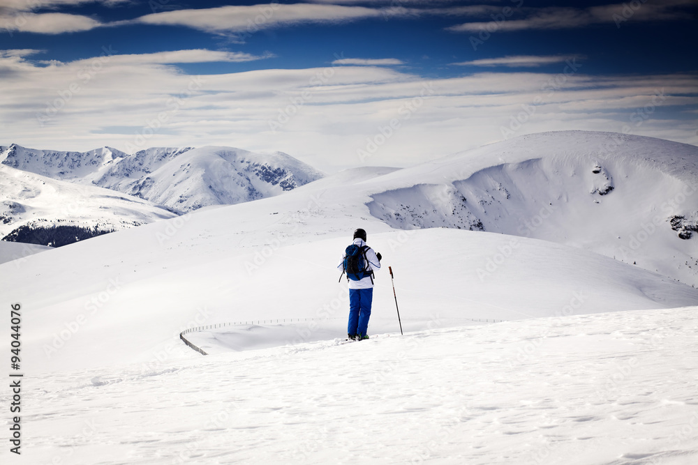 Cross-country skier - snowy mountains in the background