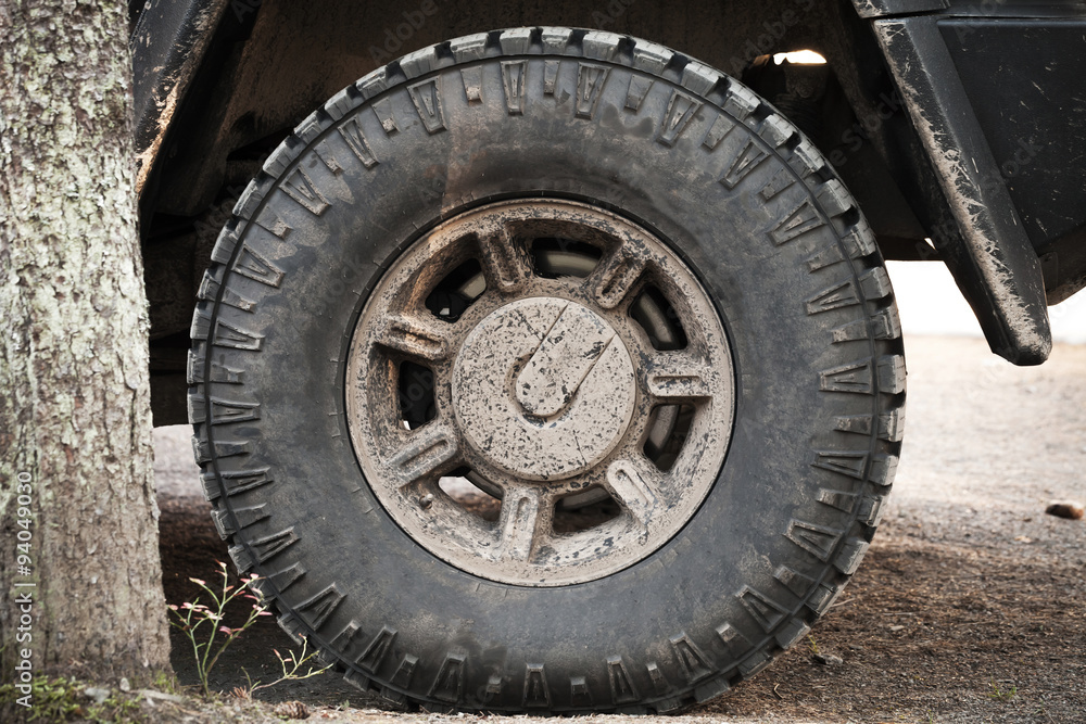 Dirty car wheel stands on rural road