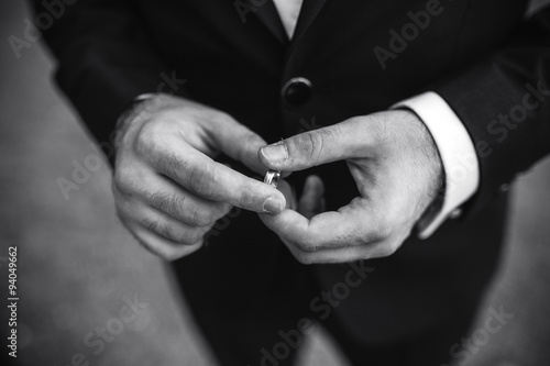 groom holding a wedding ring