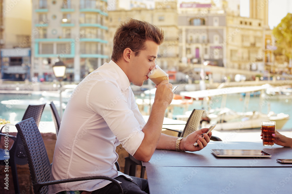 Man sitting at the cafe checking his smartphone Man sitting at the cafe checking his smartphone
