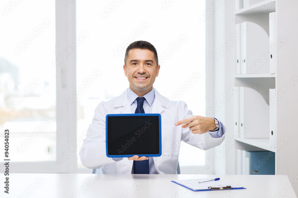 smiling male doctor showing tablet pc blank screen