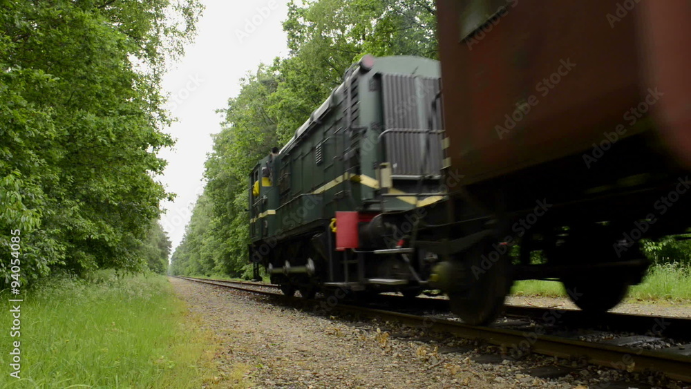 Old diesel freight train pulling various railroad cars in the countryside. Old diesel freight train pulling various railroad cars in the countryside.